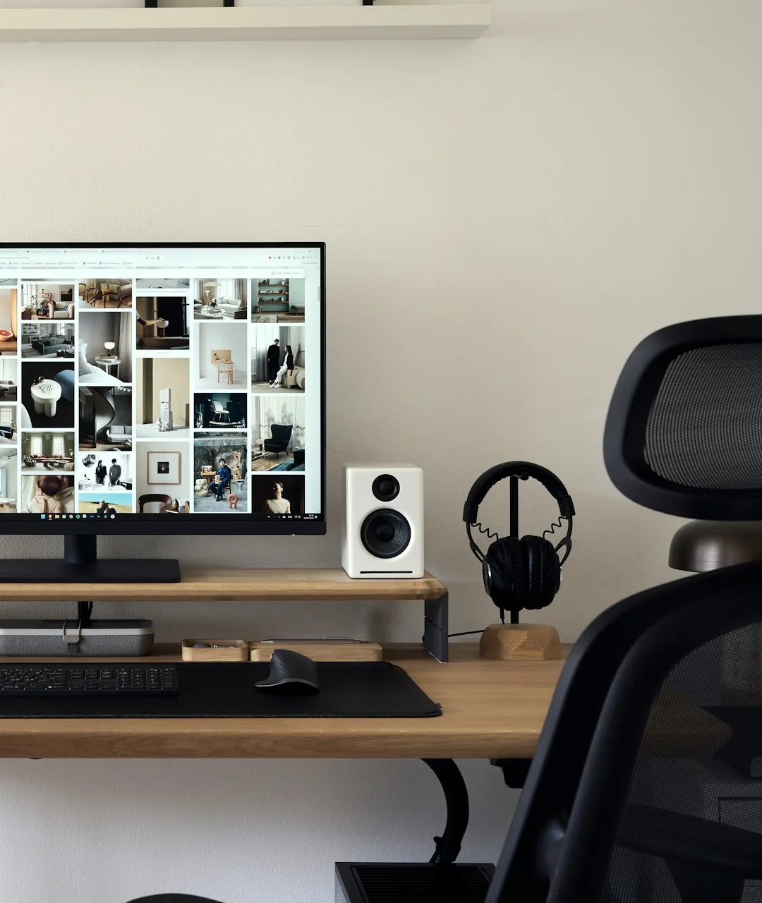 Mesa de trabalho com monitor, teclado e fones de ouvido